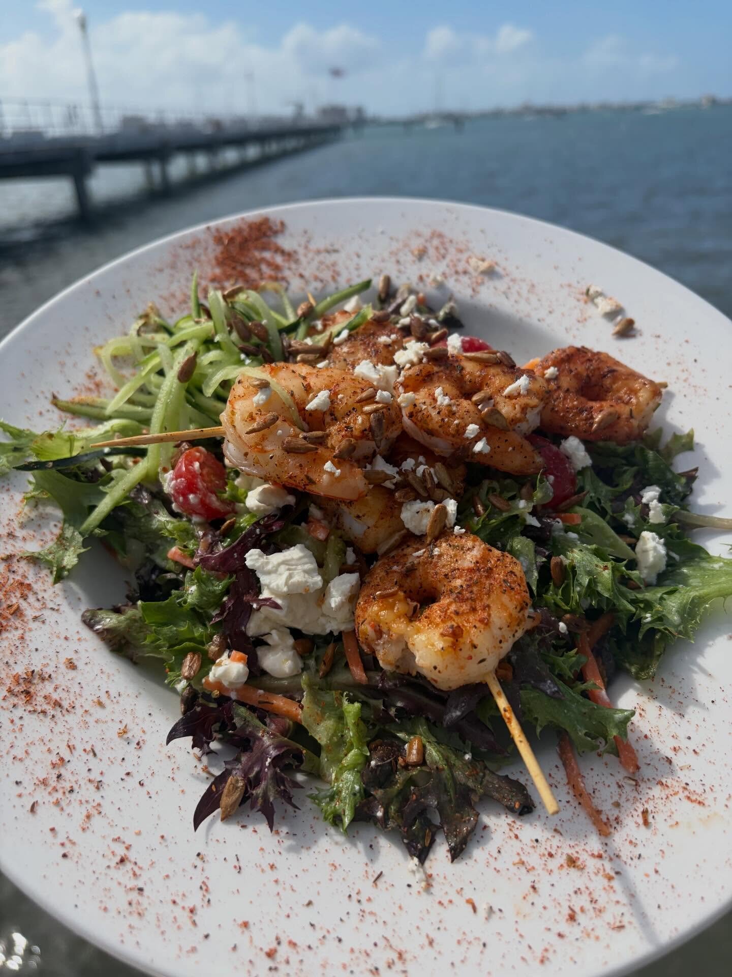 A salad on O'Maddy's deck with the pier and bay behind