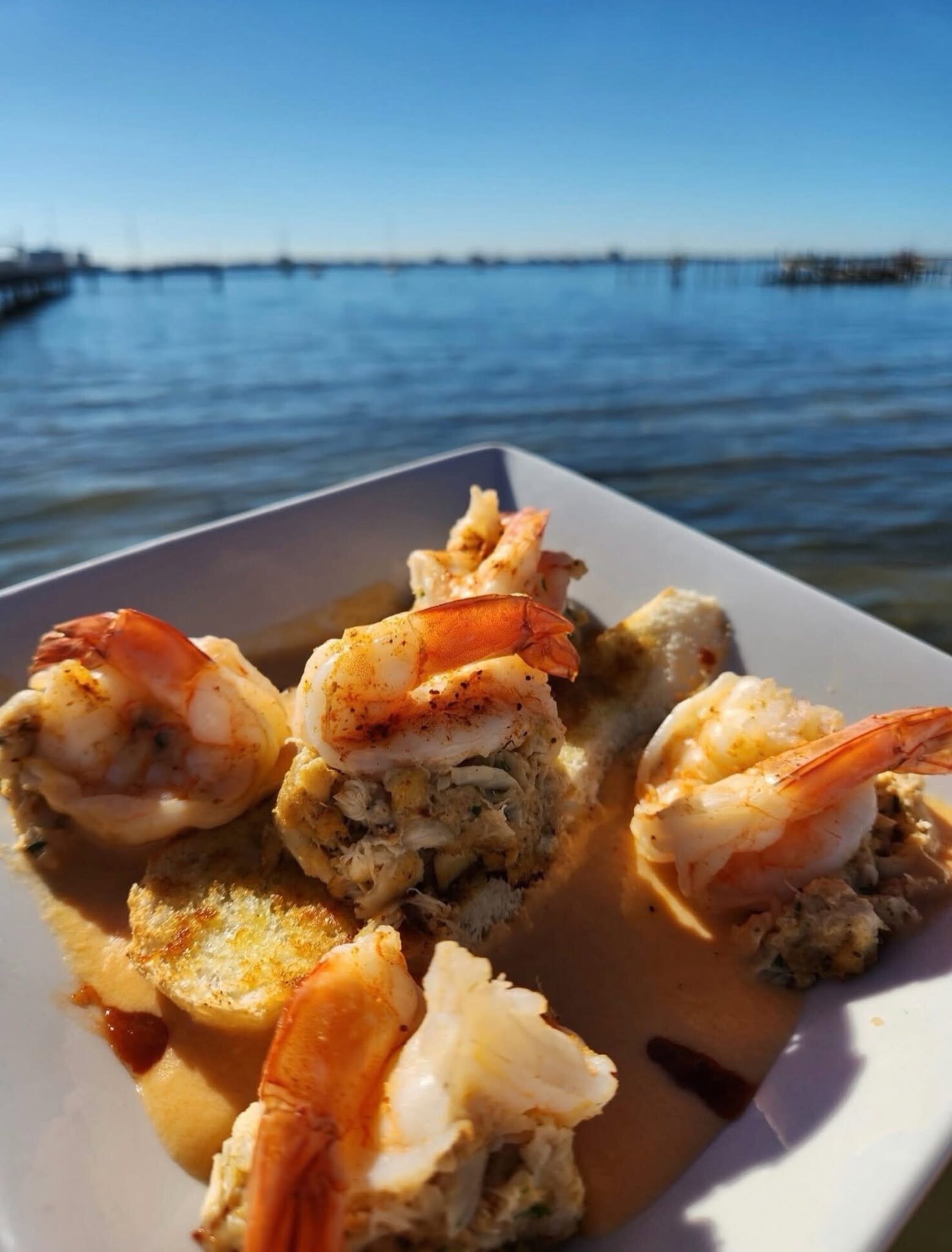 Crab-stuffed shrimp on the O’Maddy’s rail with the Gulfport pier behind